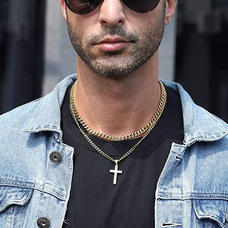 A man showcases layered styling with a Cuban link chain and a cross pendant