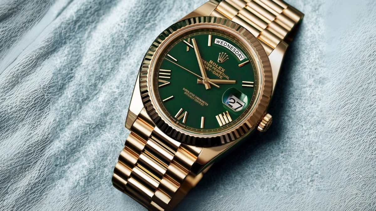 Gold Rolex Day-Date watch with green dial and Roman numeral markers