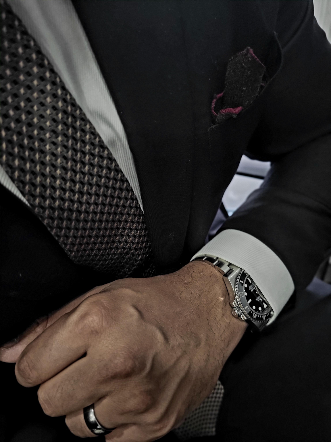 Rolex Submariner Date styled with a formal business suit emphasizing the combination of luxury watch and tailored attire