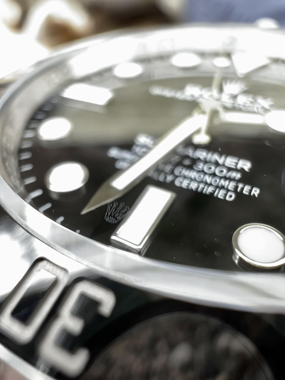 Close-up of Rolex laser-etched crown at 6 o'clock on sapphire crystal as an authentication feature