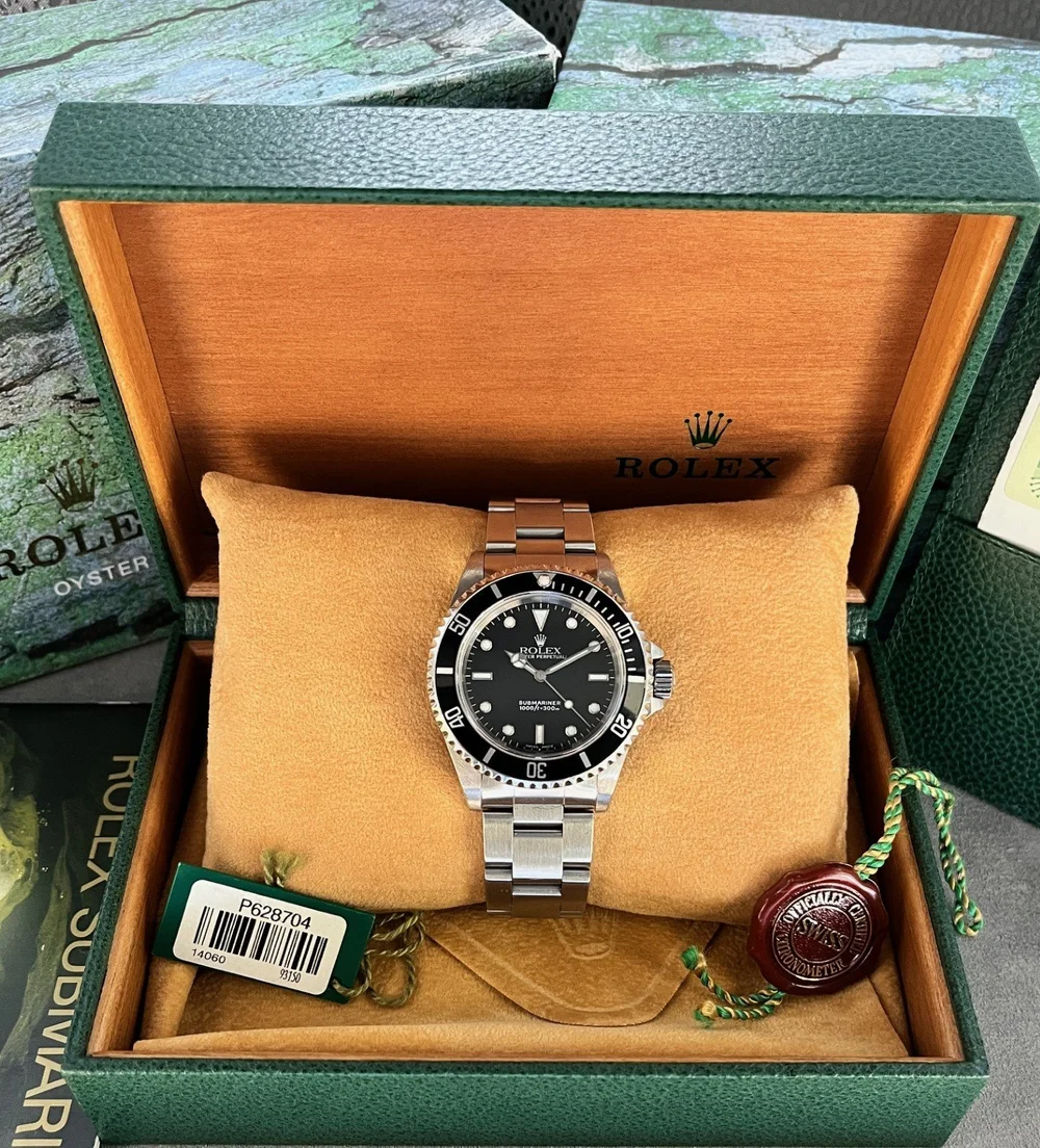 Rolex Submariner 14060M vintage model displayed in original box with authenticity tags and documentation, showcasing collector appeal