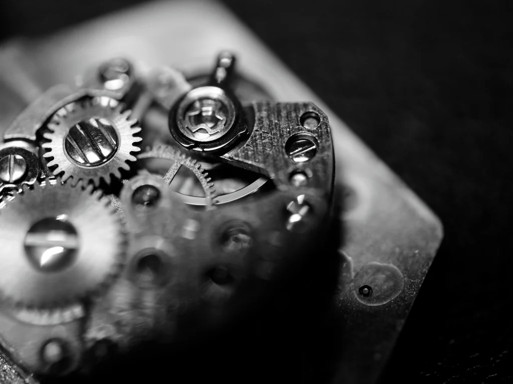 Macro shot of luxury watch movement showing polished gears and intricate mechanical detail.