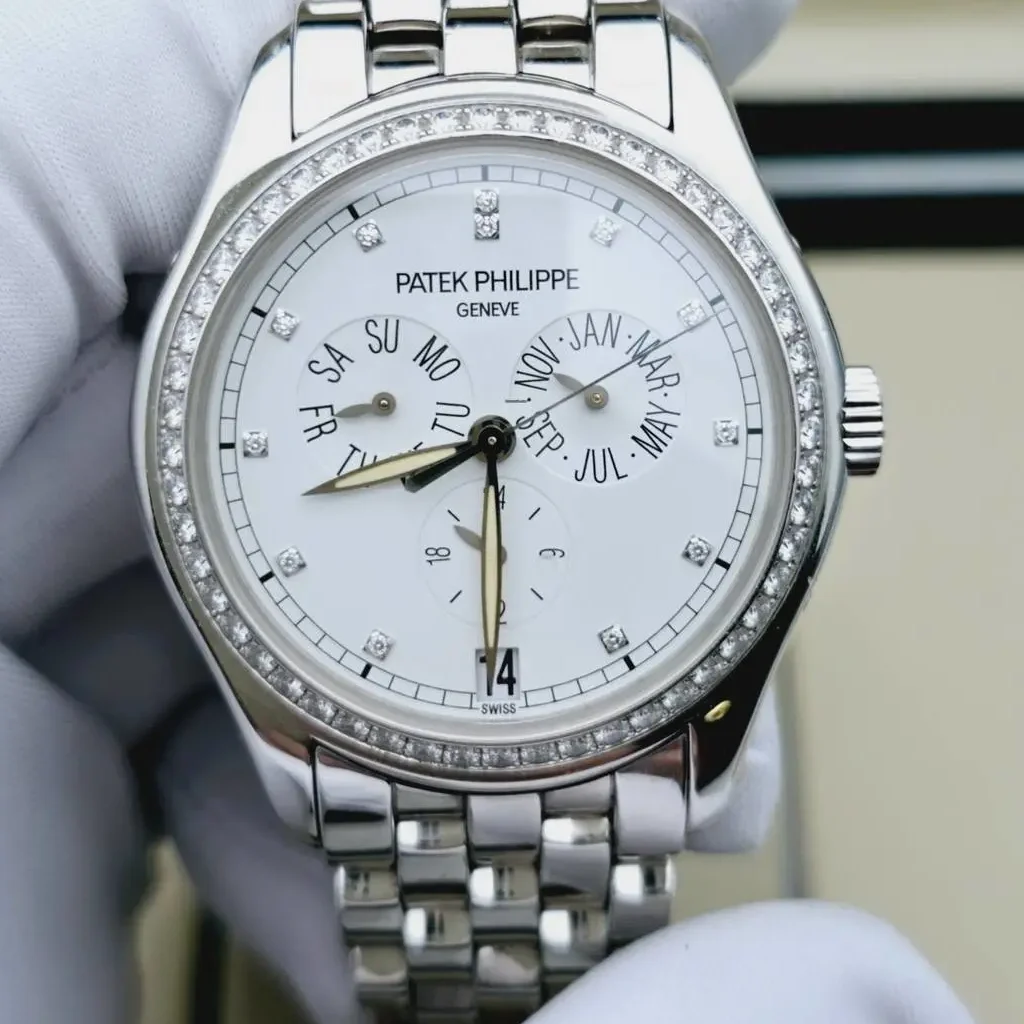 Patek Philippe Annual Calendar watch with diamond bezel and stainless steel bracelet.