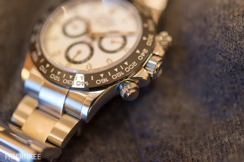 Close-up of Rolex Daytona with white dial and black ceramic bezel on stainless steel bracelet.