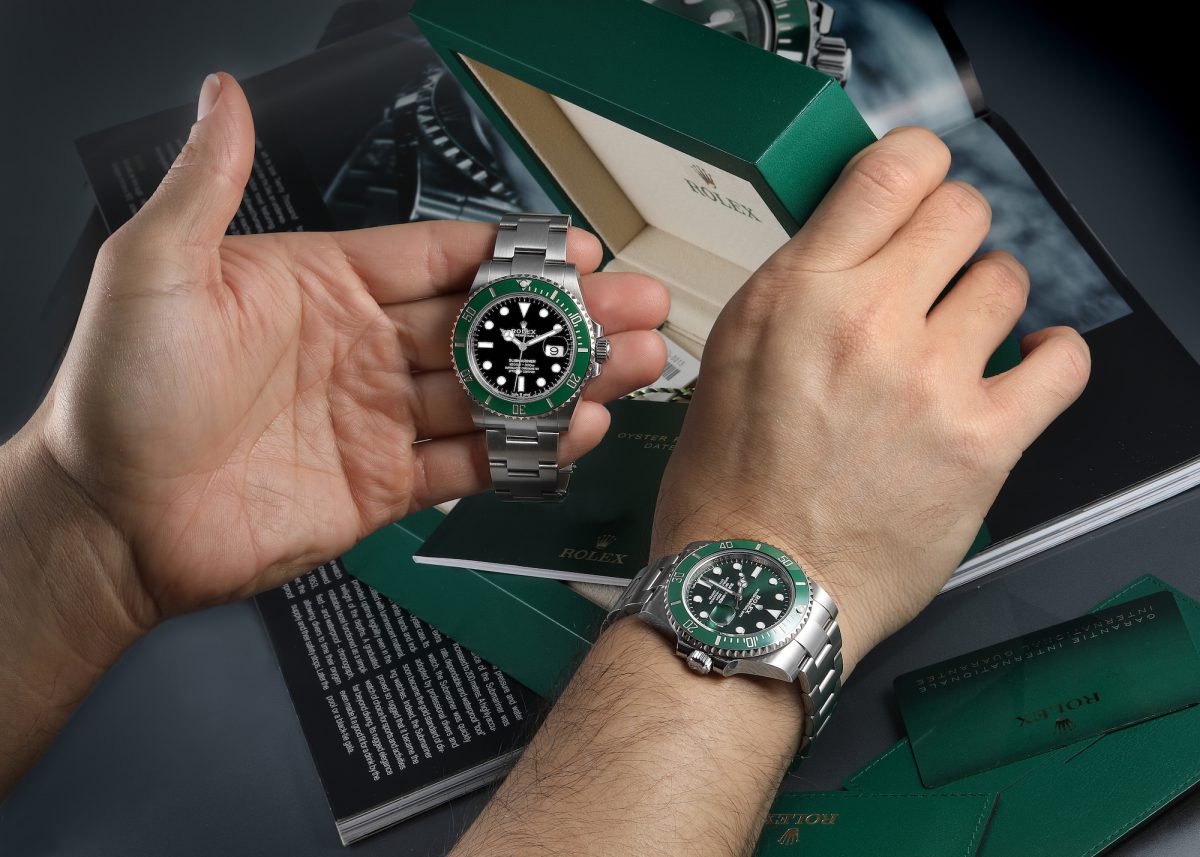 Rolex Submariner Date with green bezel shown during unboxing and on wrist