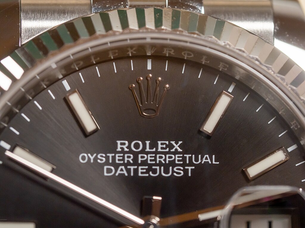 Close-up of Rolex Datejust dial showing logo, crown emblem, and luxury watch craftsmanship.