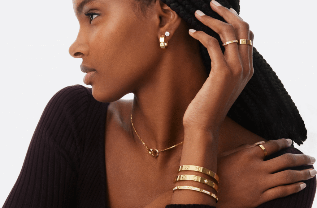 Woman wearing Cartier Love yellow gold bracelet, ring, earrings and necklace luxury jewelry set