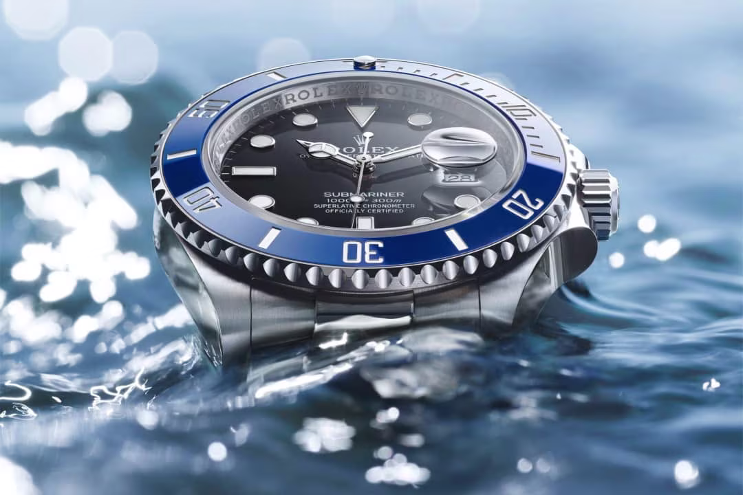 Rolex Submariner with blue ceramic bezel and black dial in water, luxury Swiss dive watch close-up