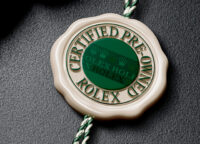 Rolex Certified Pre-Owned seal with green medallion and braided tag, official authenticity emblem